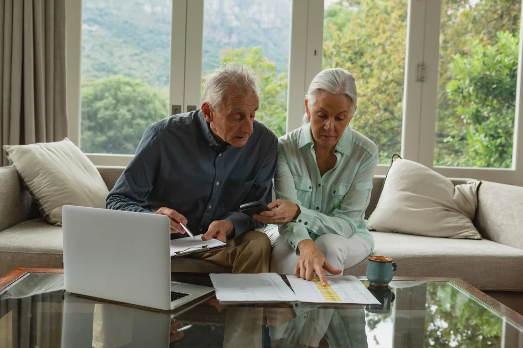 active senior couple calculating bills living room